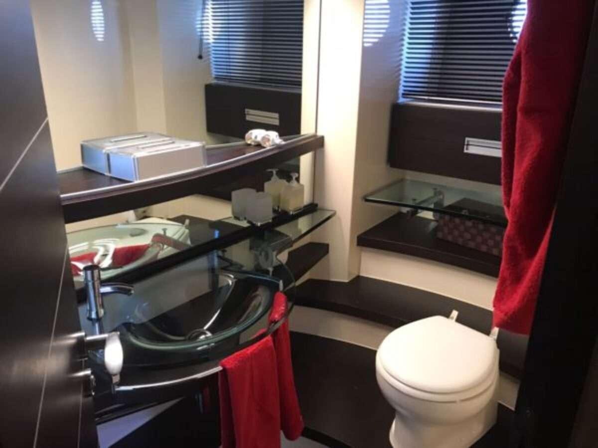 a bathroom with a toilet and a shelf with towels aboard ZIPI ZAPE Yacht for Charter