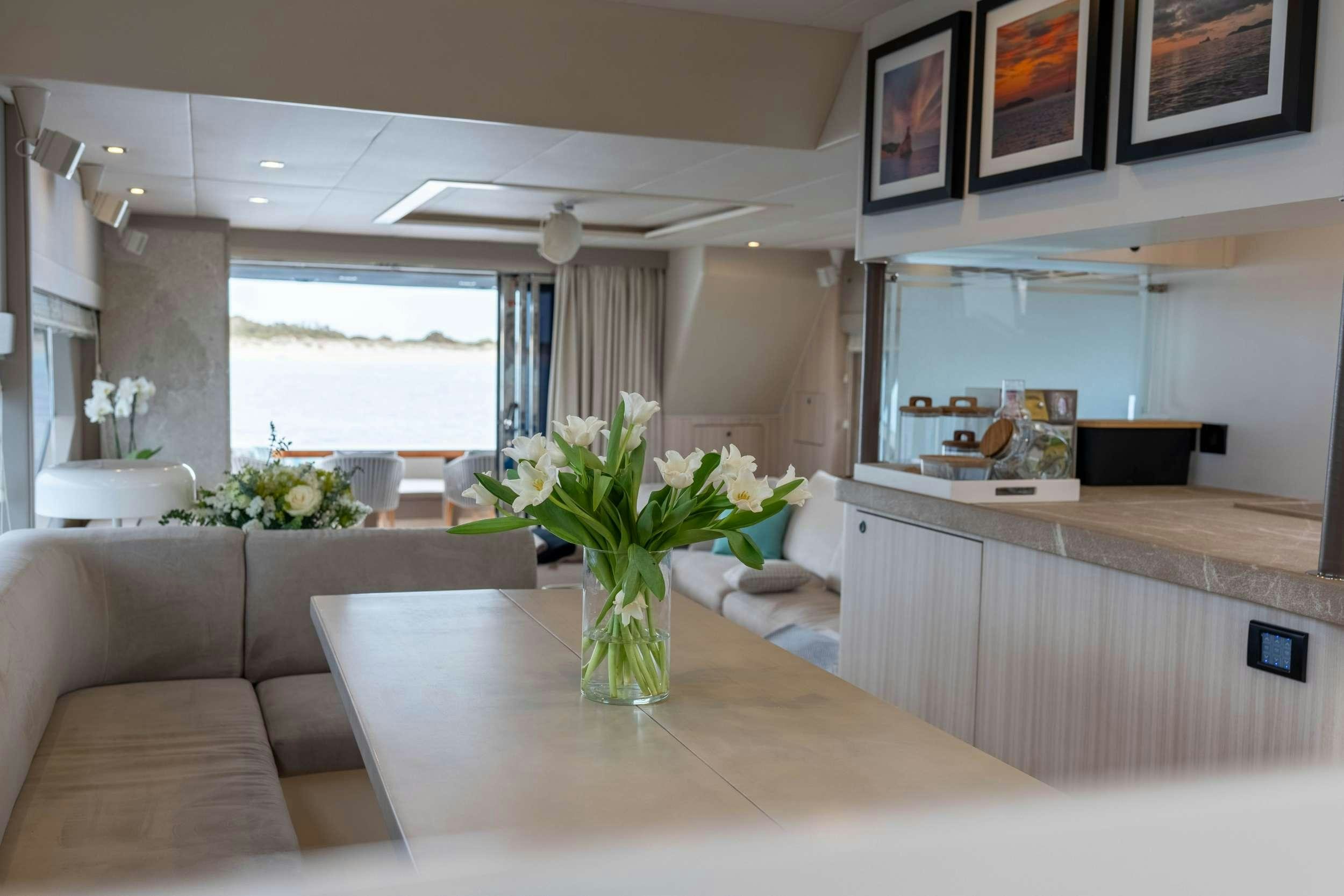 a living room with a table and couches aboard AMMONITE Yacht for Charter