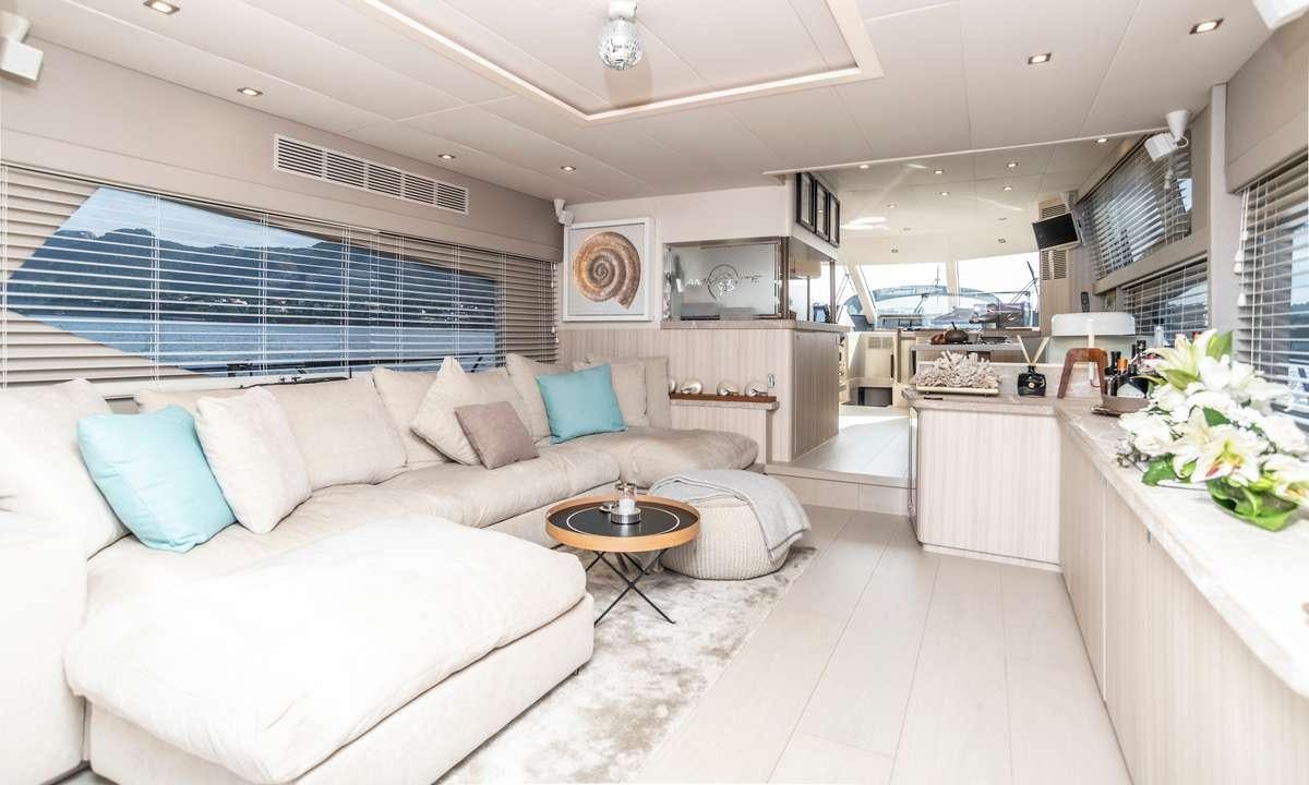 a living room with white furniture aboard AMMONITE Yacht for Charter