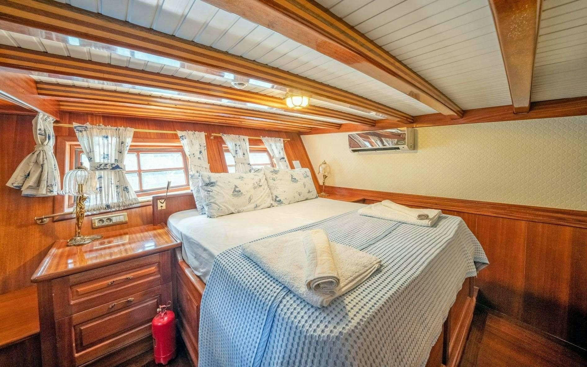 a bedroom with a bed and a dresser aboard ADMIRAL Yacht for Charter