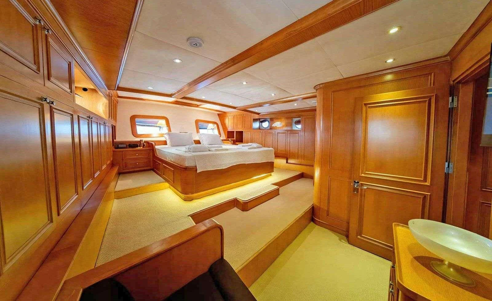 a room with a bed and a desk aboard BABYLON Yacht for Charter