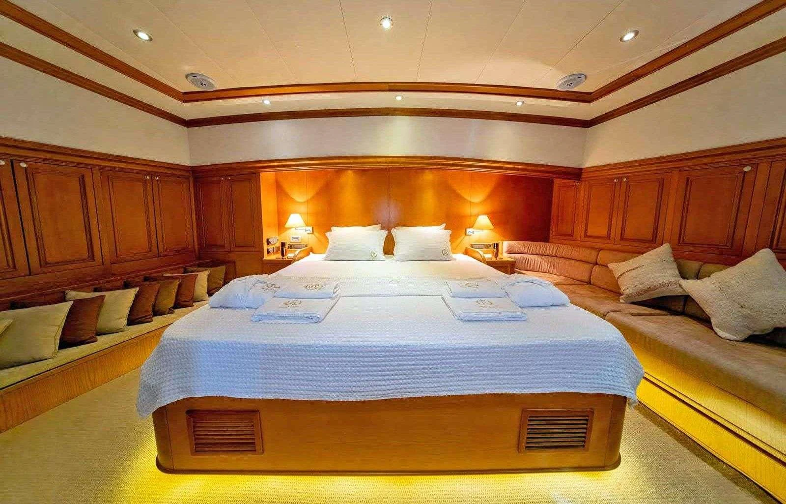 a room with a bed and a couch aboard BABYLON Yacht for Charter