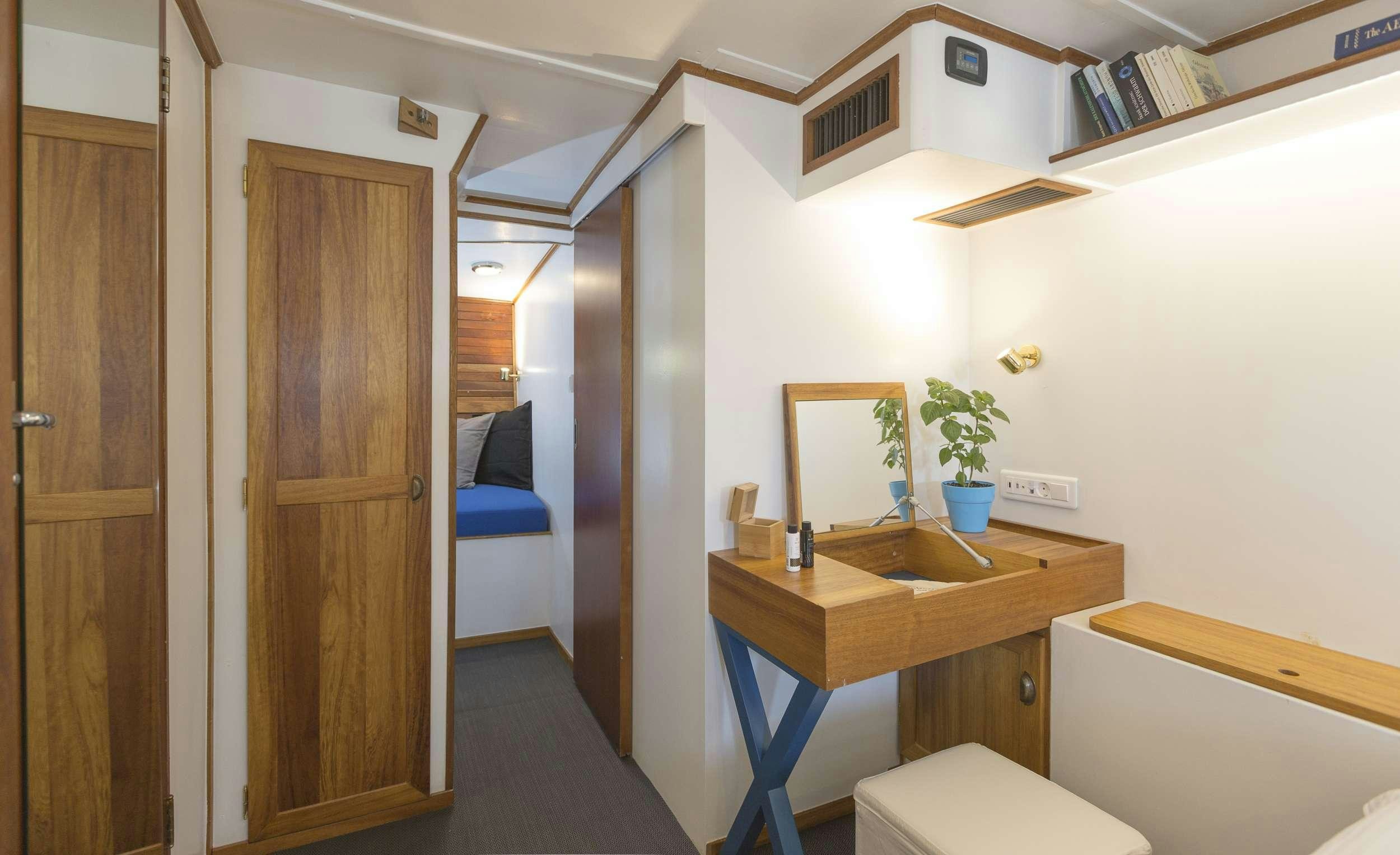 a small bathroom with a sink and a bed aboard COSMOS Yacht for Charter