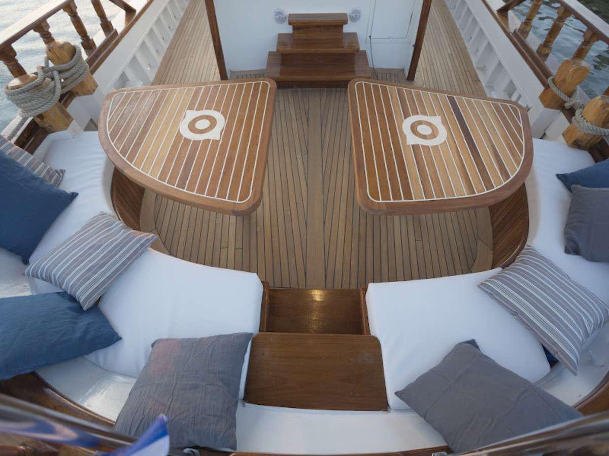 a bed with a wooden headboard aboard COSMOS Yacht for Charter