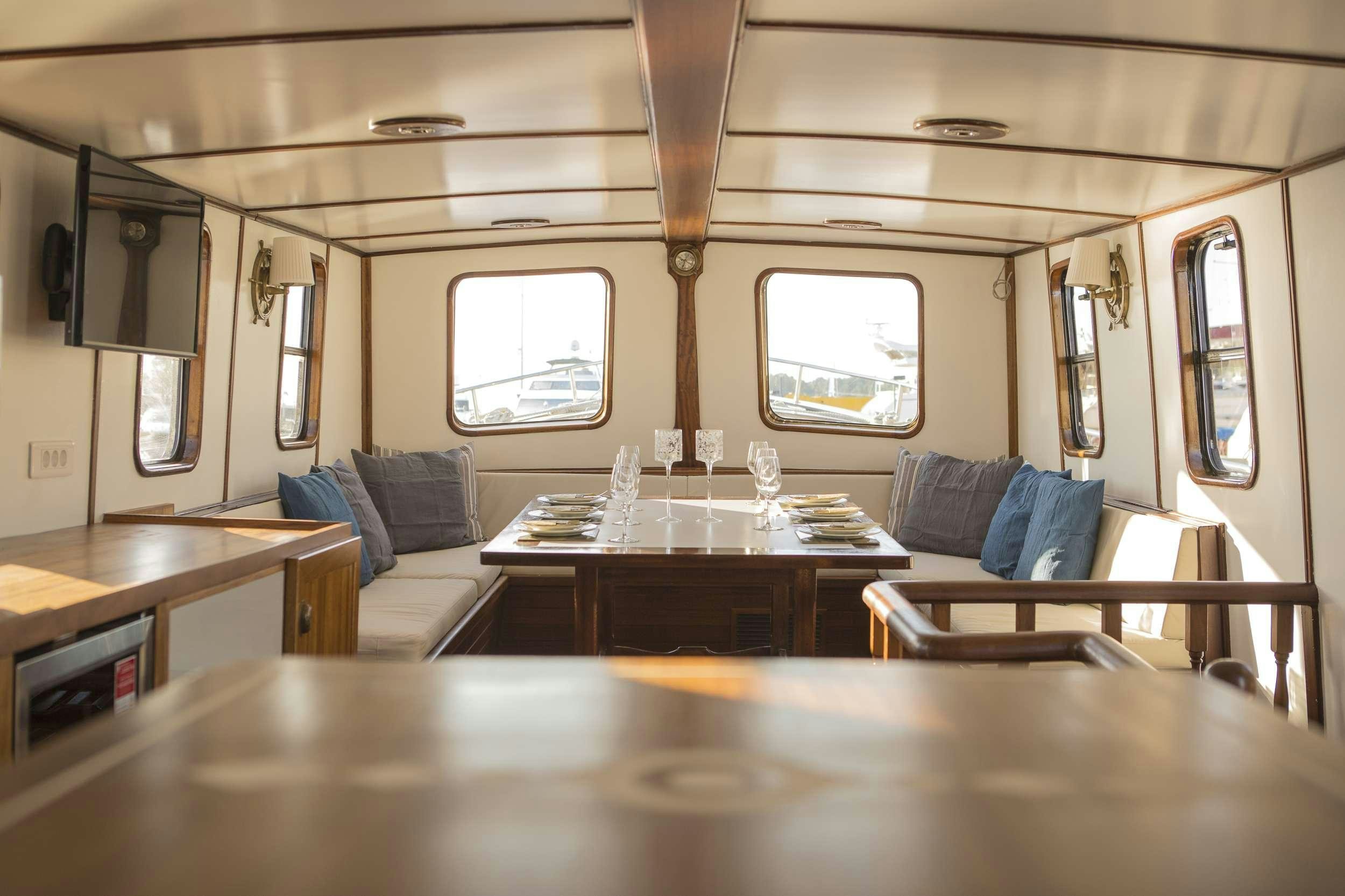 a room with a table and couch aboard COSMOS Yacht for Charter