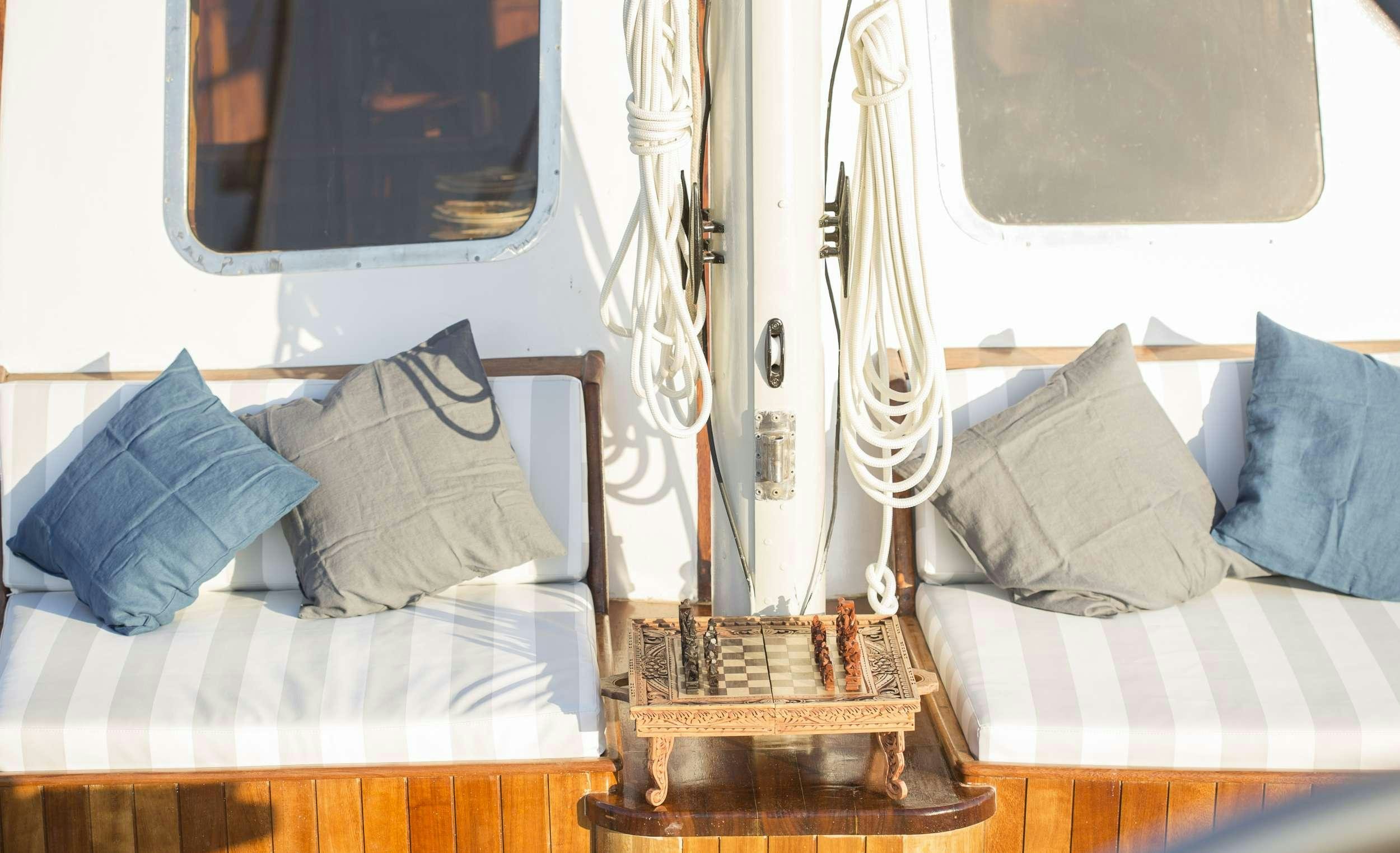 a boat with a bed and a chair aboard COSMOS Yacht for Charter
