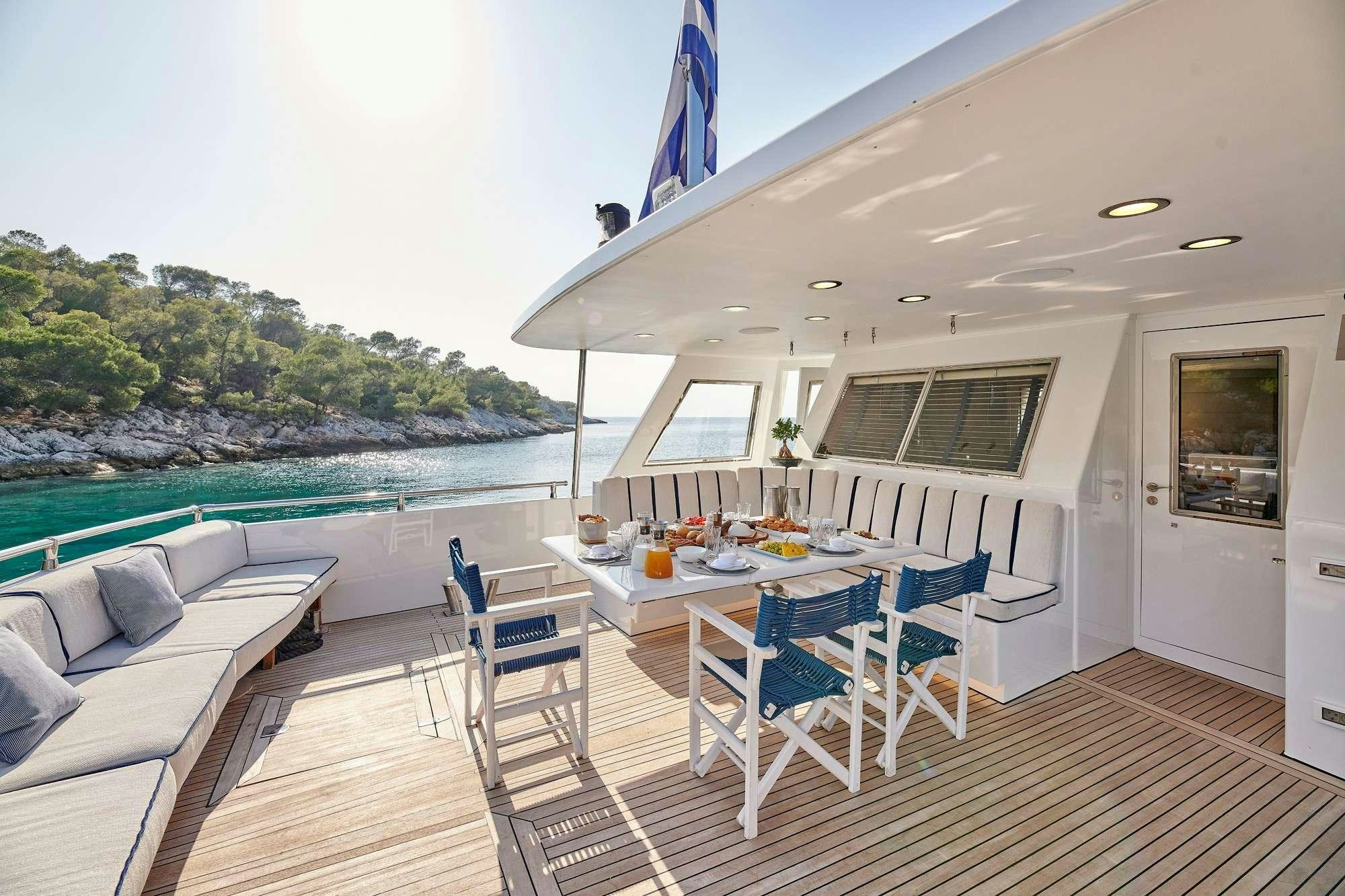 a deck with a table and chairs aboard ALAYA Yacht for Charter