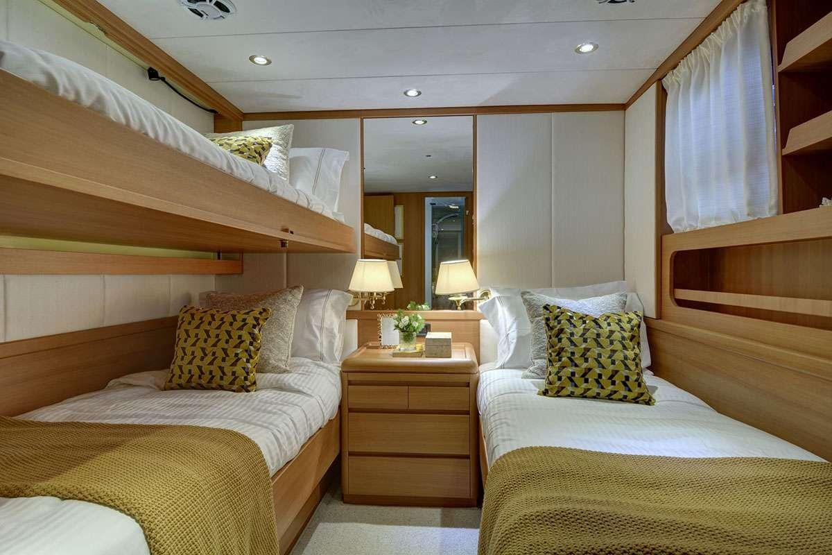 a room with a bed and a dresser aboard KARMA Yacht for Charter