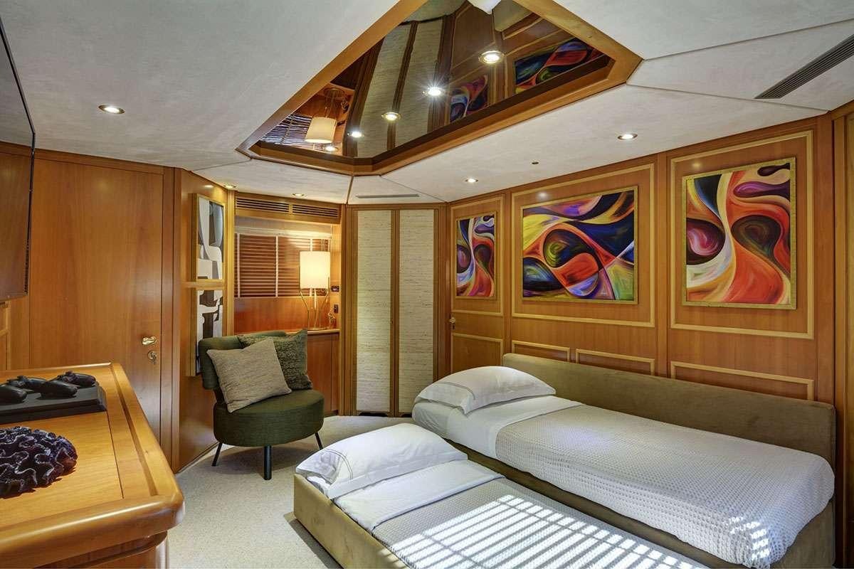a room with a bed and a chair aboard KARMA Yacht for Charter