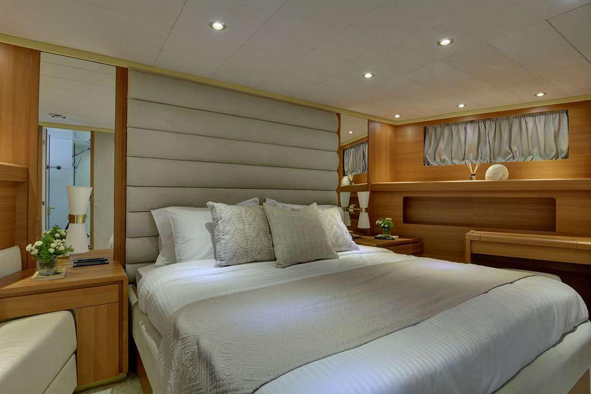 a bed with white sheets aboard KARMA Yacht for Charter