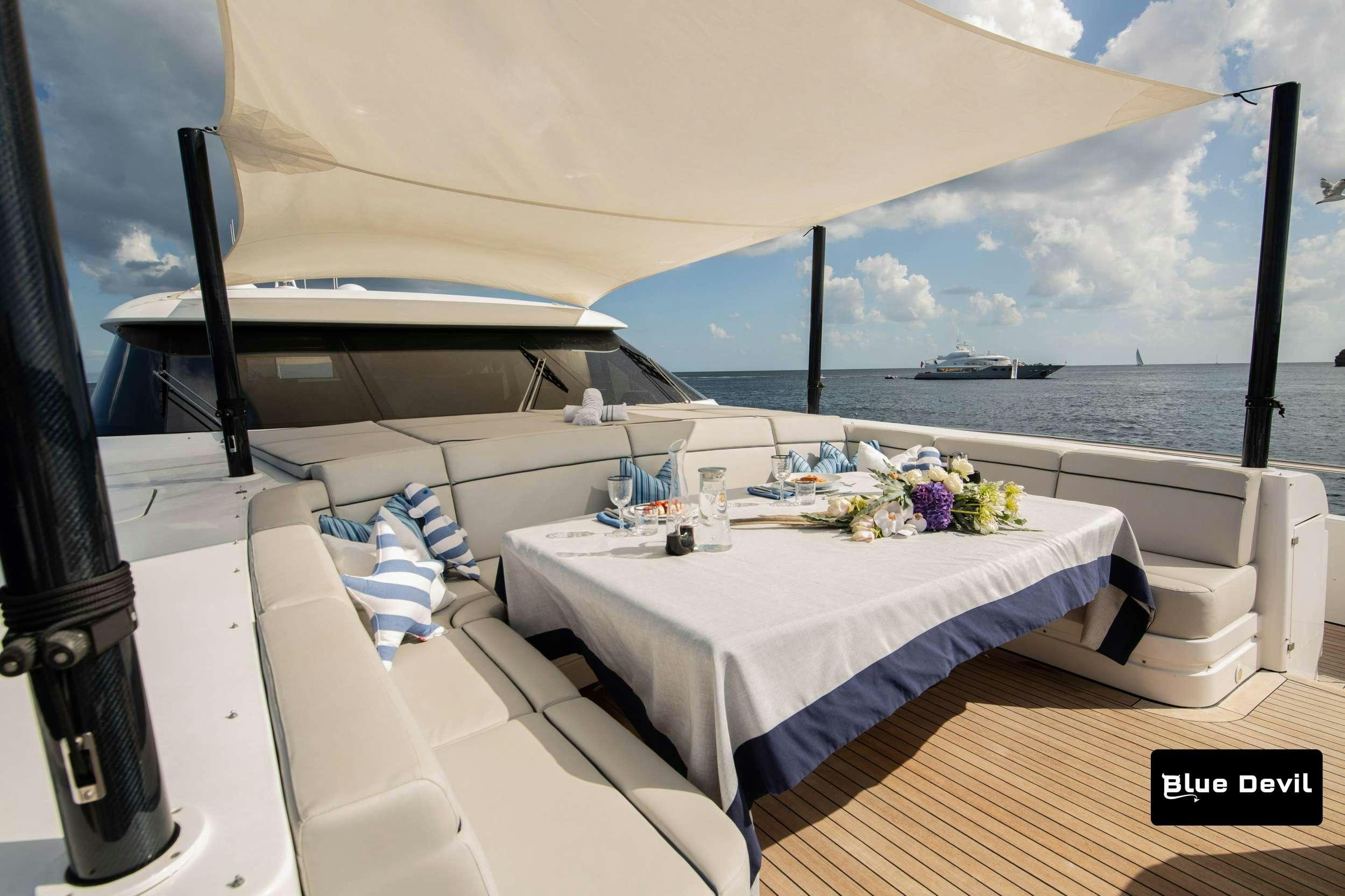 a table and chairs on a balcony aboard BLUE DEVIL Yacht for Charter