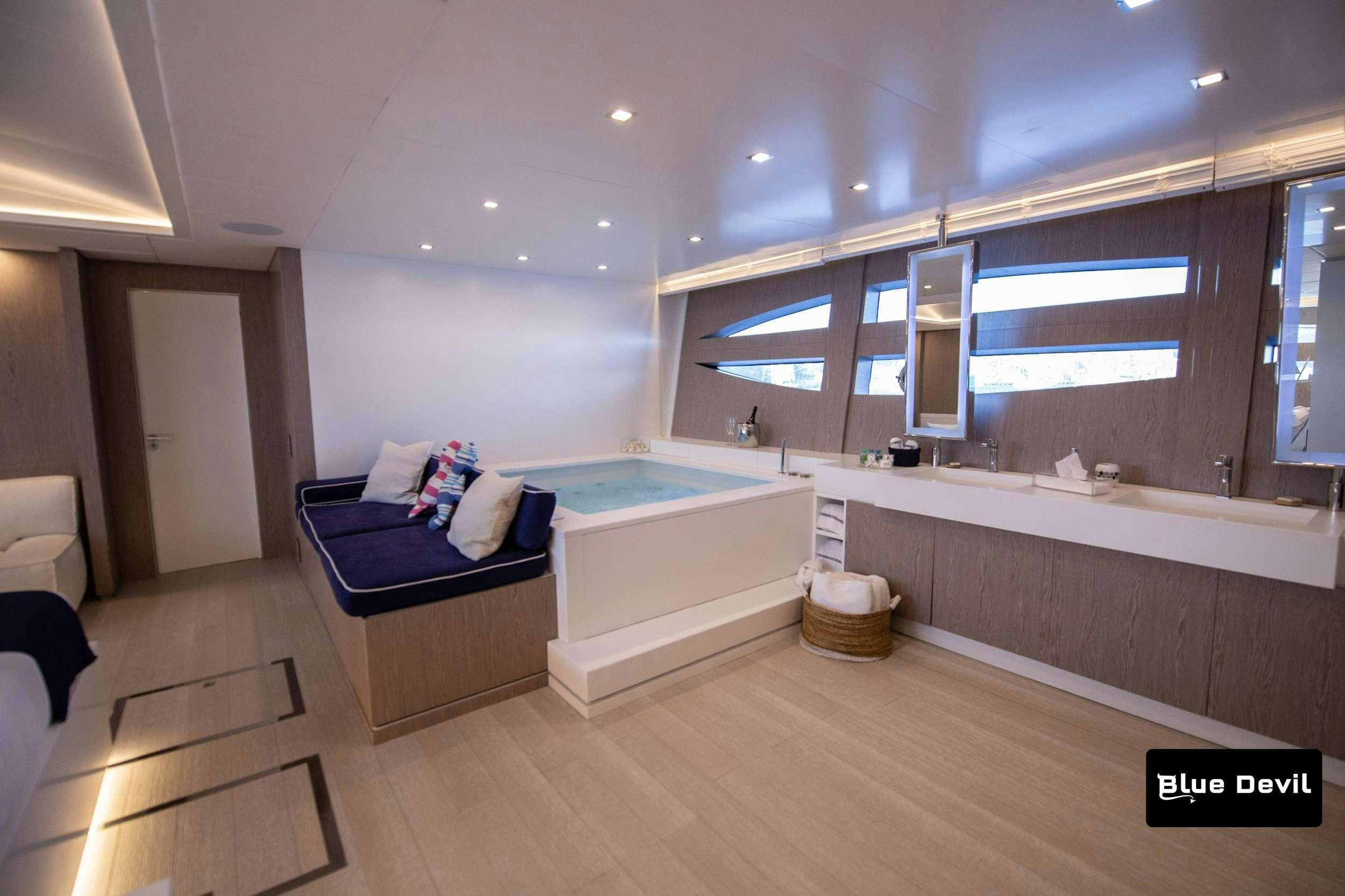 a bathroom with a tub and a bed aboard BLUE DEVIL Yacht for Charter