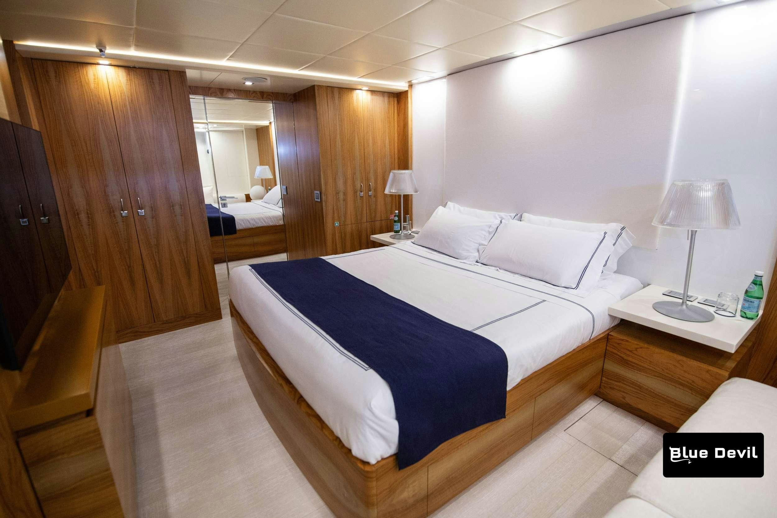 a room with a bed and a desk aboard BLUE DEVIL Yacht for Charter