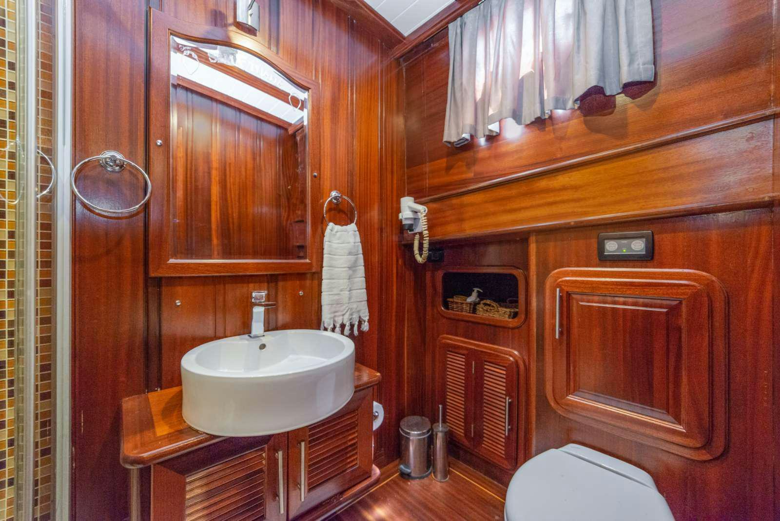 a bathroom with wood cabinets aboard SEMA TUANA Yacht for Charter