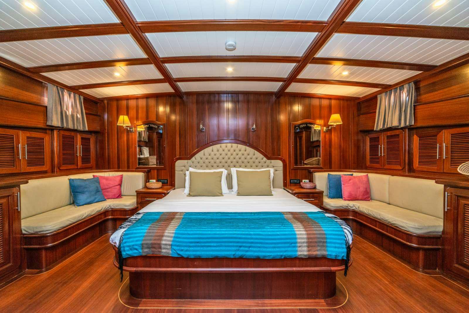a room with a bed and a couch aboard SEMA TUANA Yacht for Charter