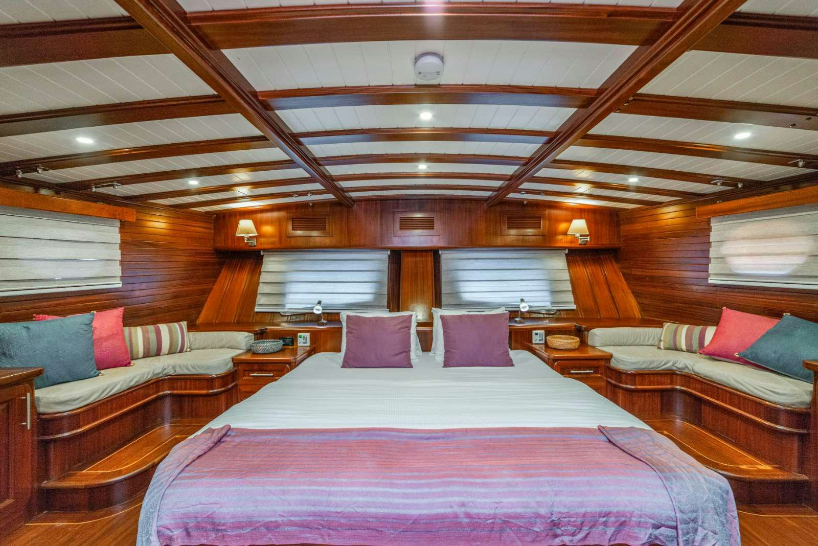 a room with a bed and a couch aboard SEMA TUANA Yacht for Charter