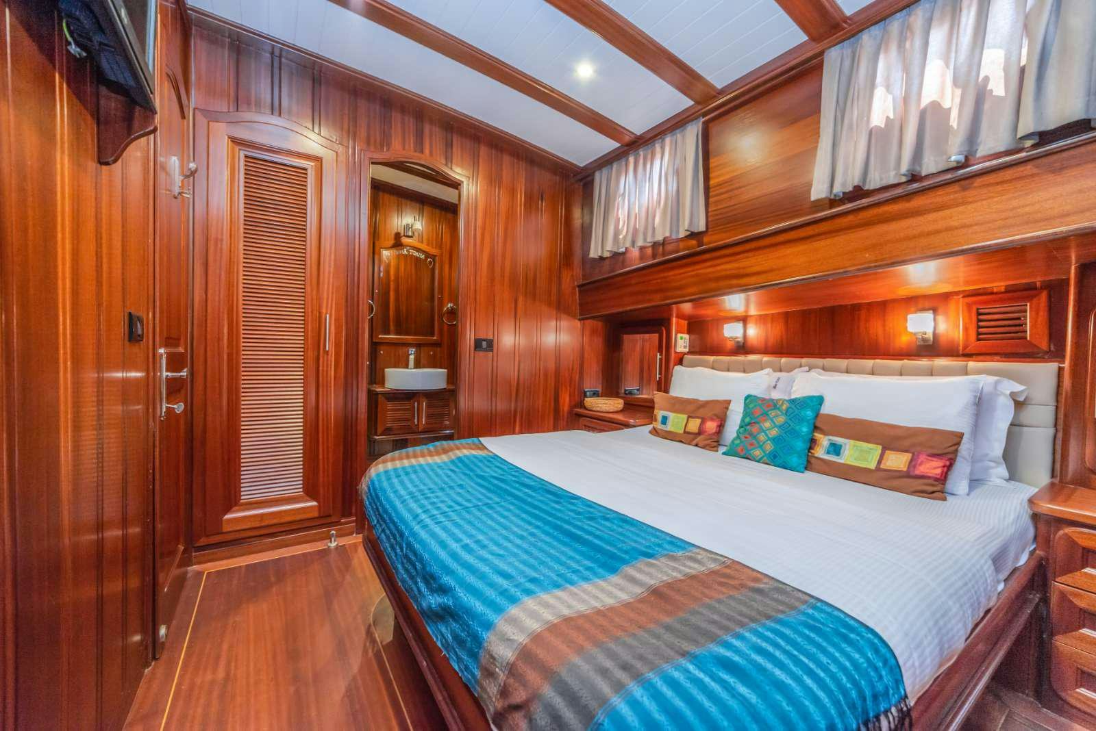 a bedroom with a bed and a closet aboard SEMA TUANA Yacht for Charter