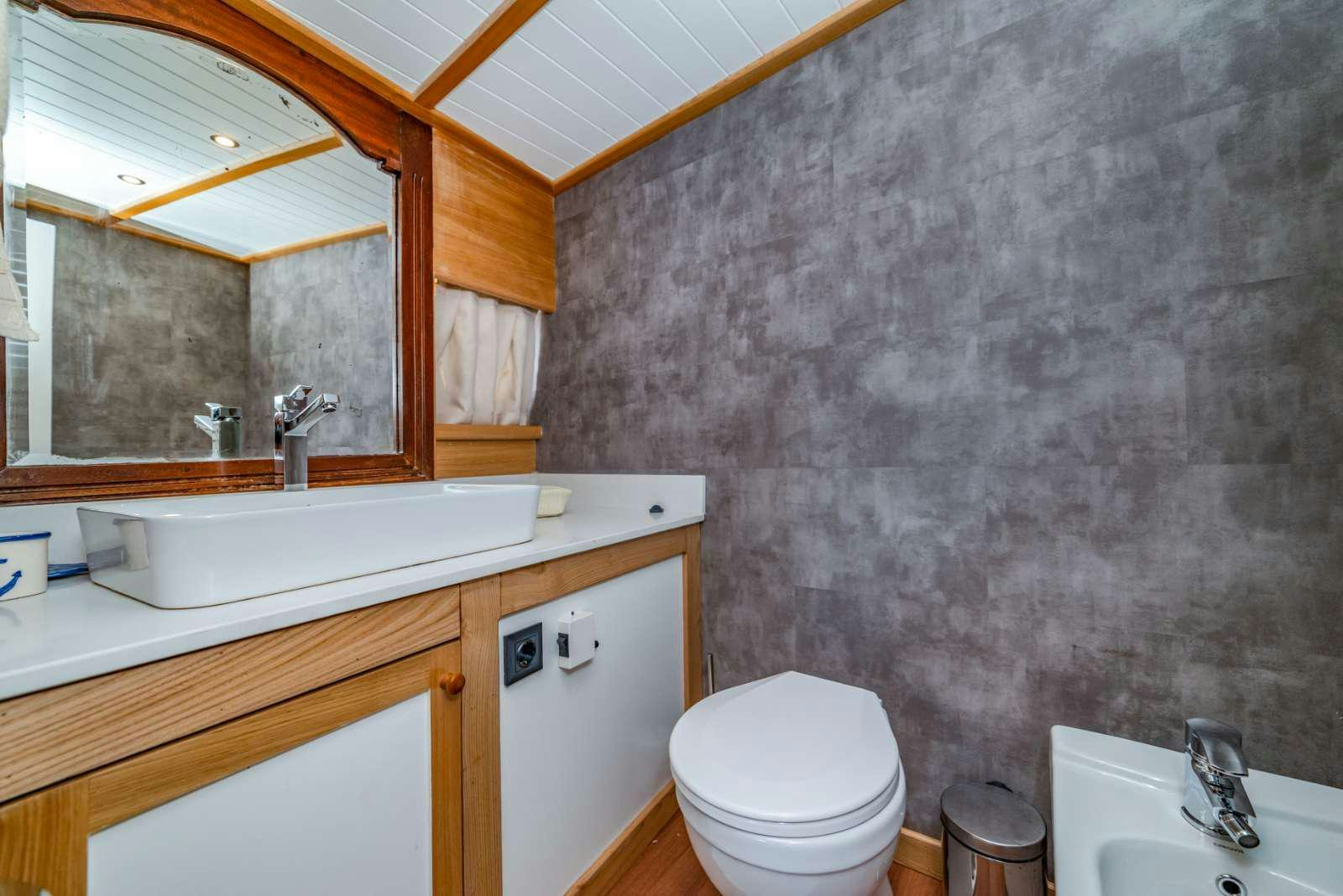 a bathroom with a stone wall aboard AMAZON SOLO Yacht for Charter