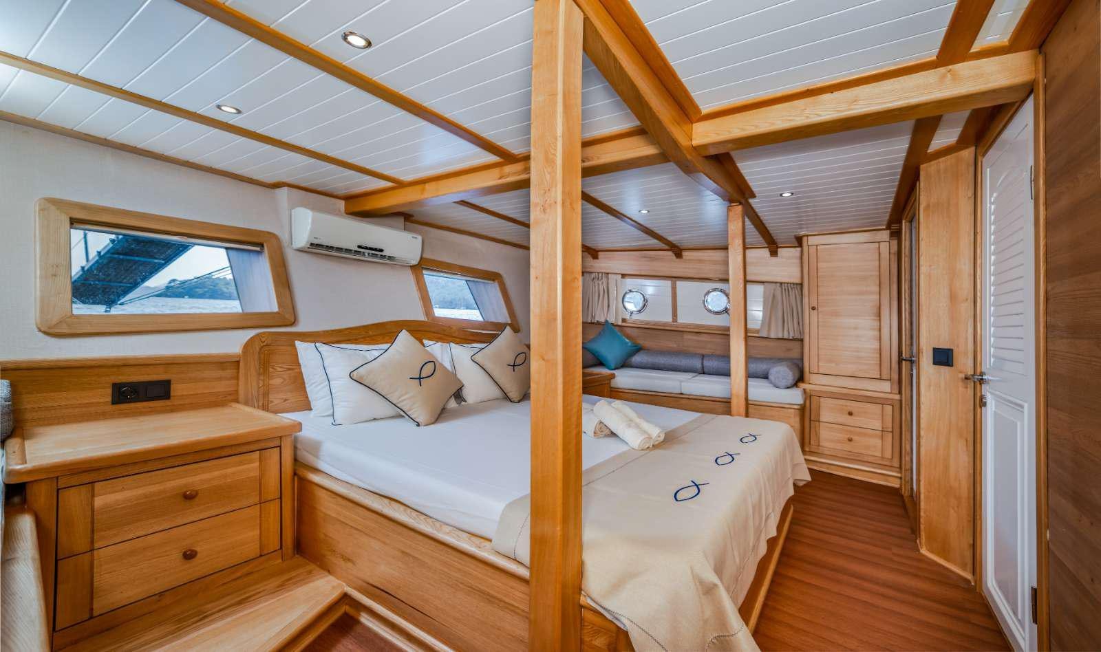 a bedroom with wood furniture aboard AMAZON SOLO Yacht for Charter