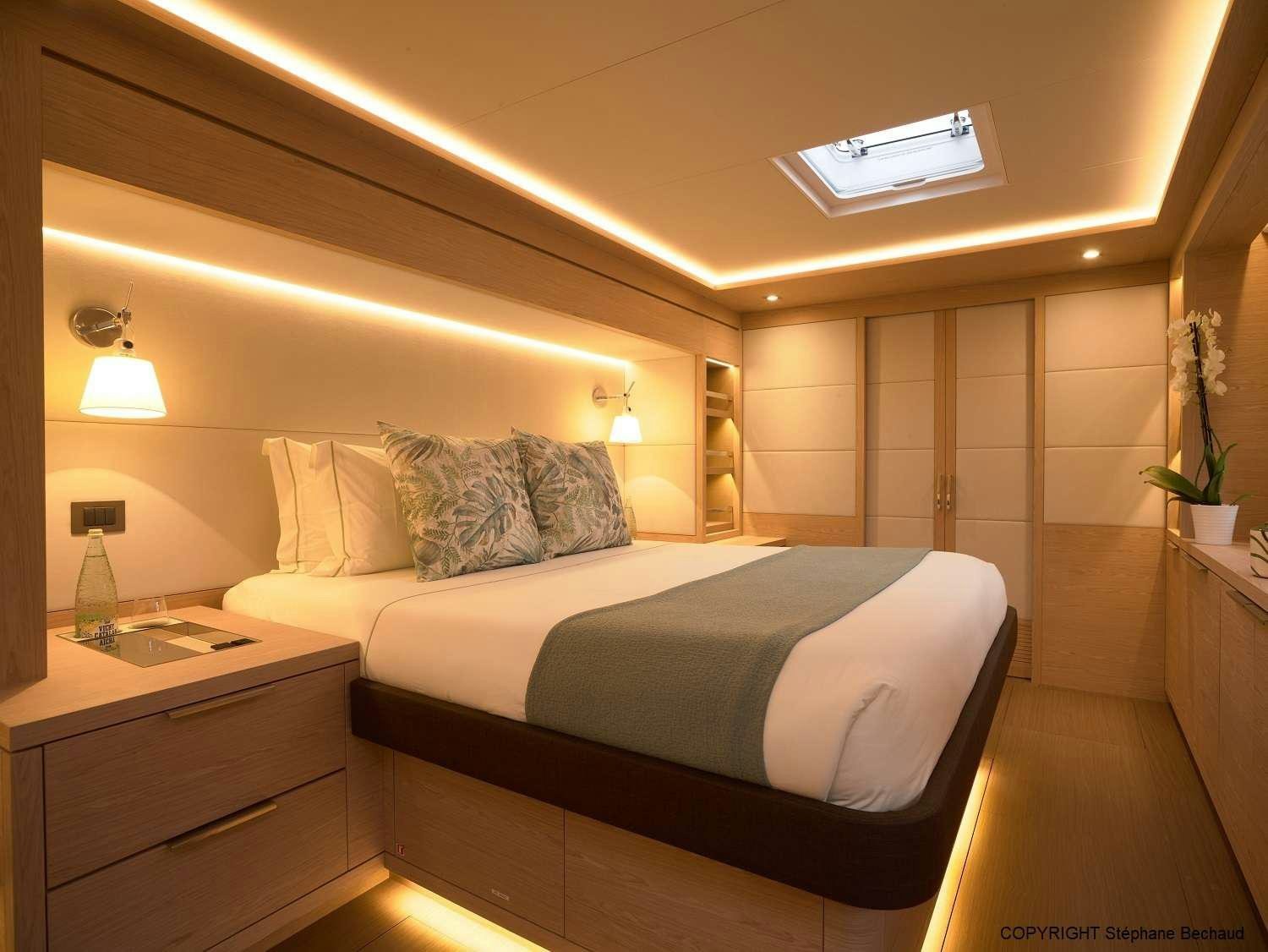 a bed with a white bed spread aboard KAJIKIA Yacht for Charter