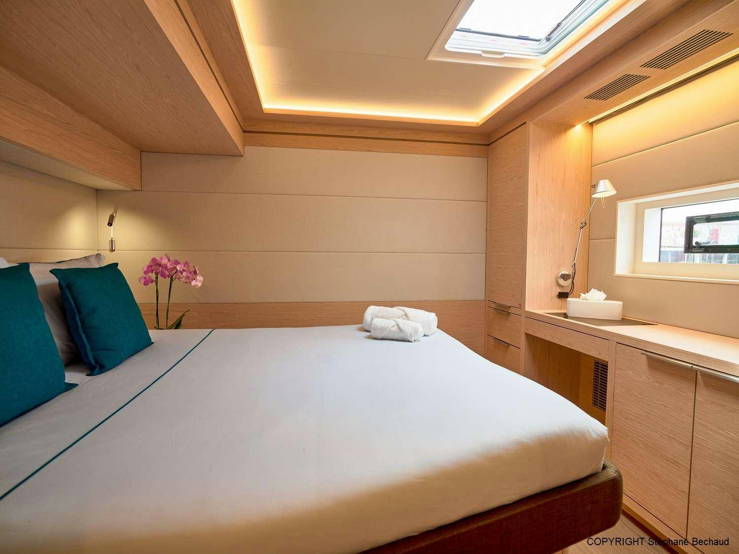 a room with a bed and a chair aboard KAJIKIA Yacht for Charter