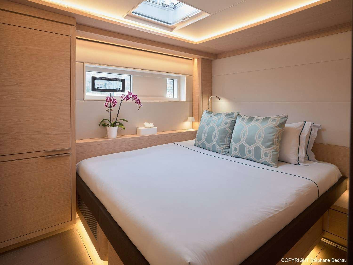 a bed with a white comforter and a white pillow aboard KAJIKIA Yacht for Charter