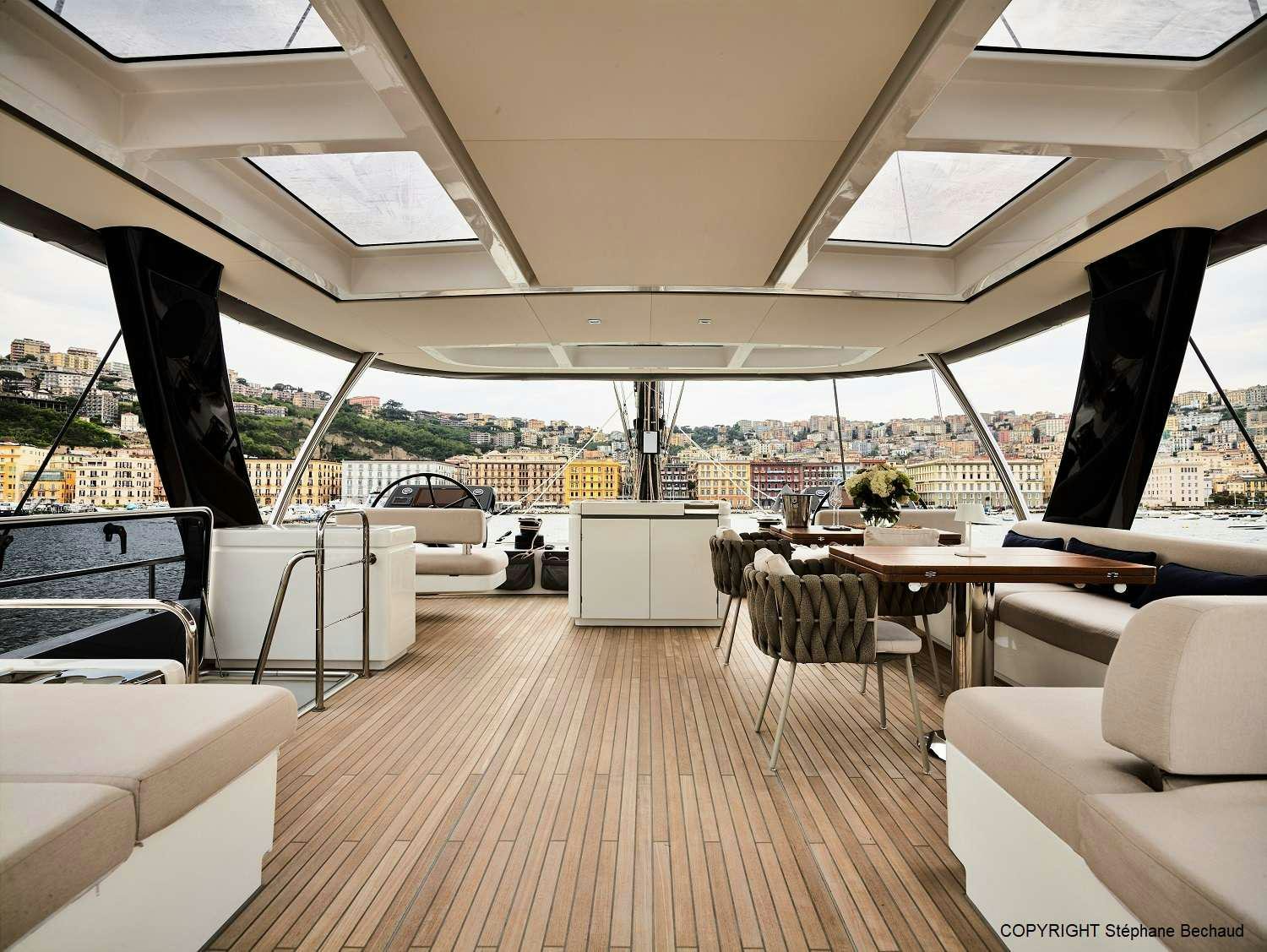 a room with a wood floor and a large window with a view of the city aboard KAJIKIA Yacht for Charter