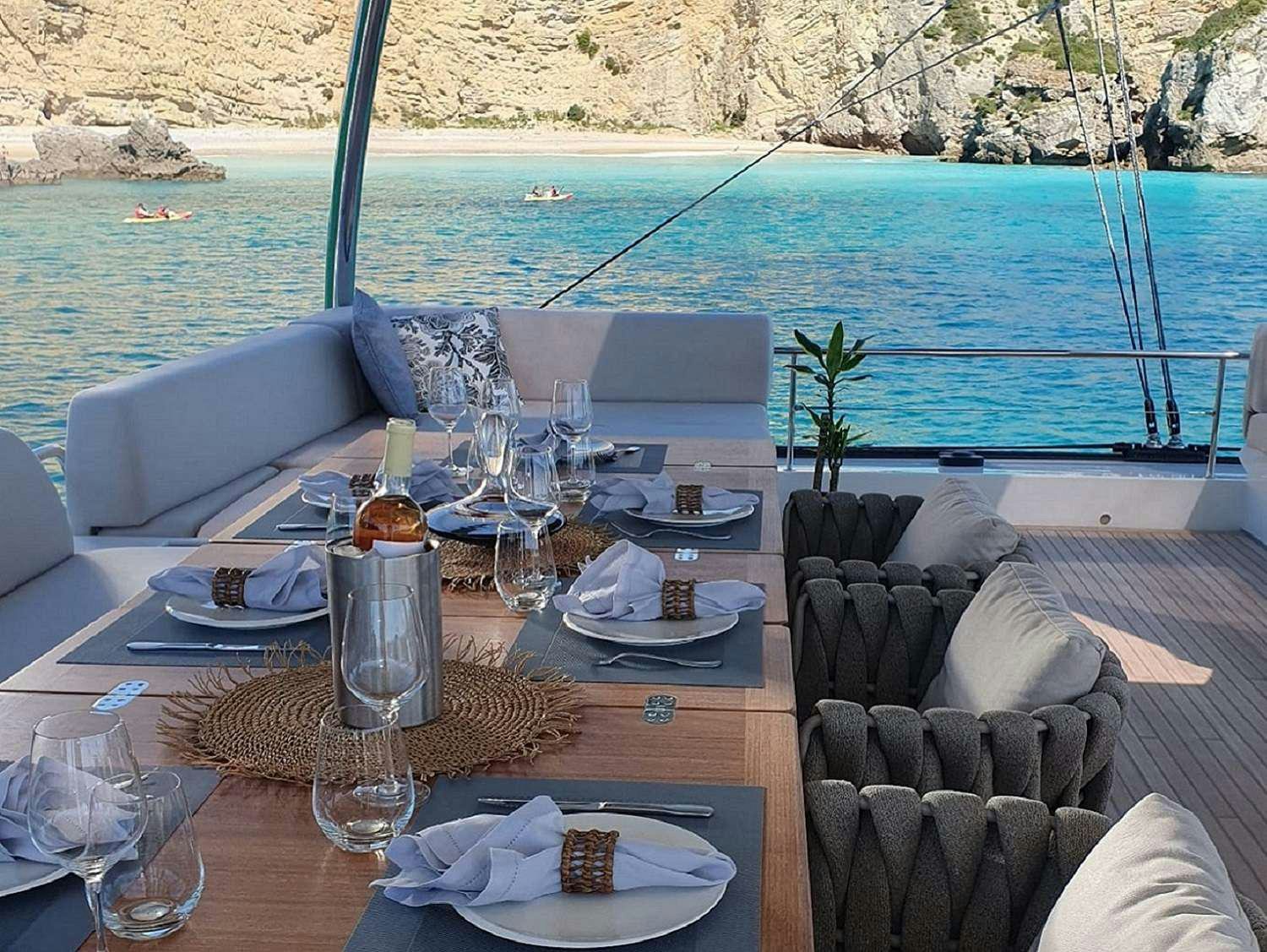 a table with plates and glasses on it aboard KAJIKIA Yacht for Charter