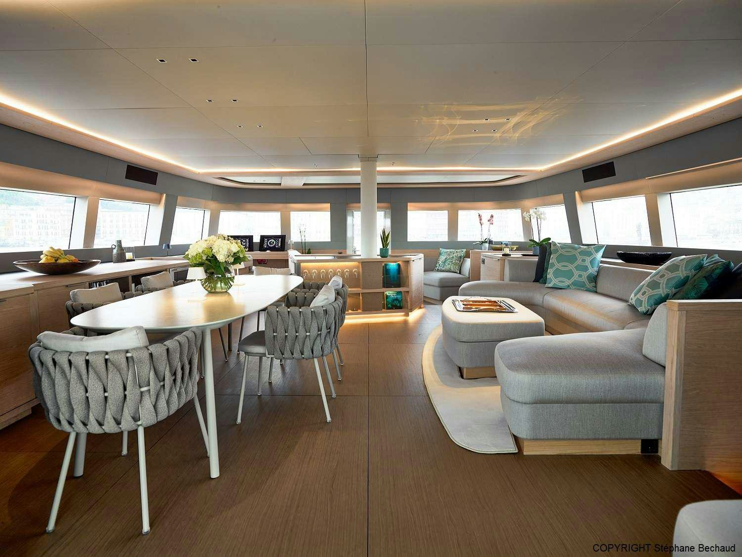 a large room with a table and chairs aboard KAJIKIA Yacht for Charter