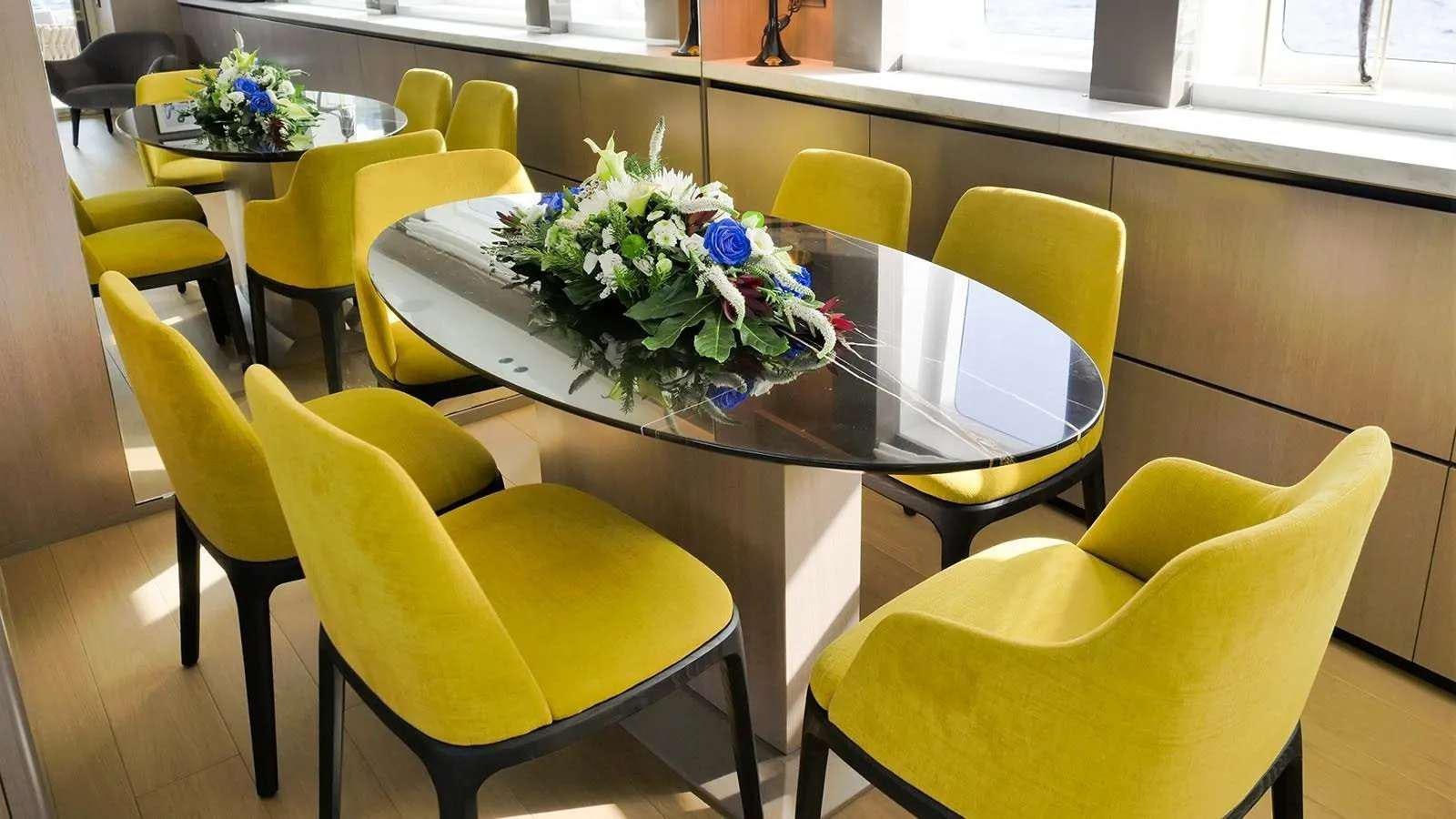 a table with chairs and a plant on it aboard MILGAUSS Yacht for Charter