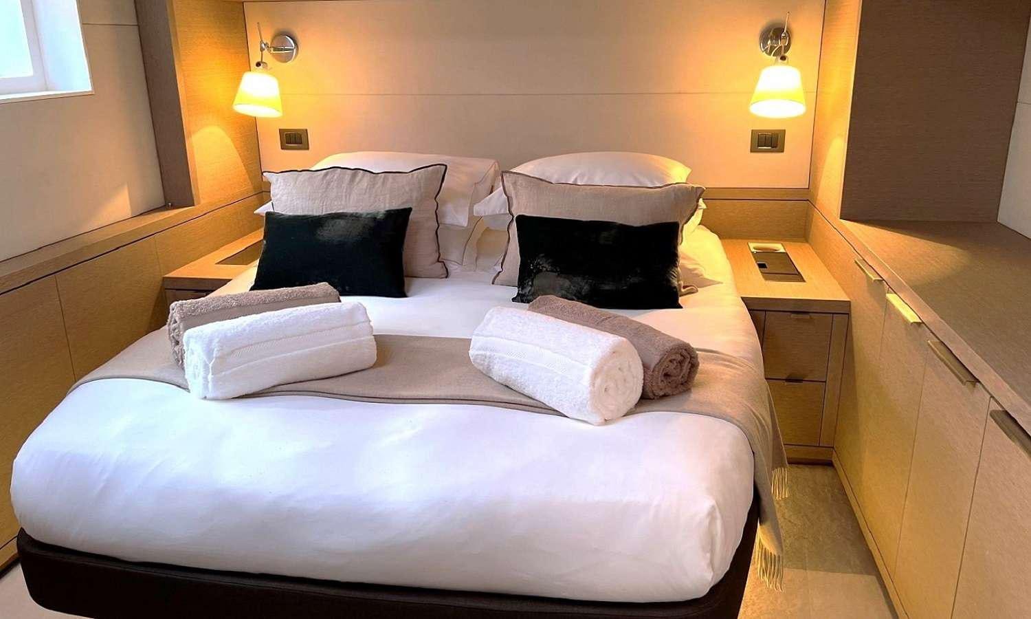a bed with white sheets and pillows aboard SYLENE Yacht for Charter