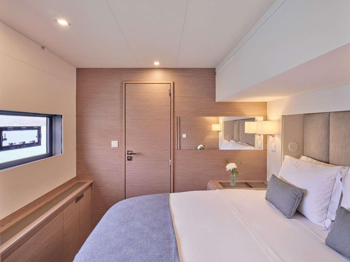 a hotel room with a bed and a television aboard DOLLY Yacht for Charter
