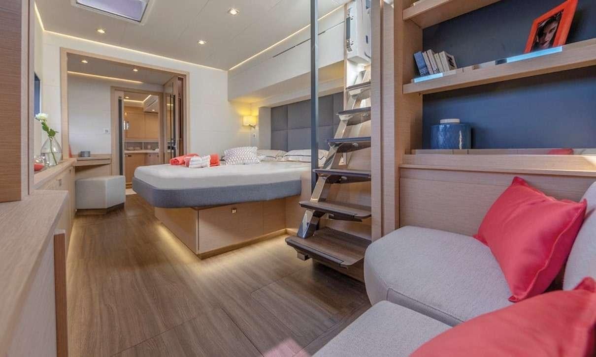 a bed and a couch in a room aboard INDULGENCE Yacht for Charter