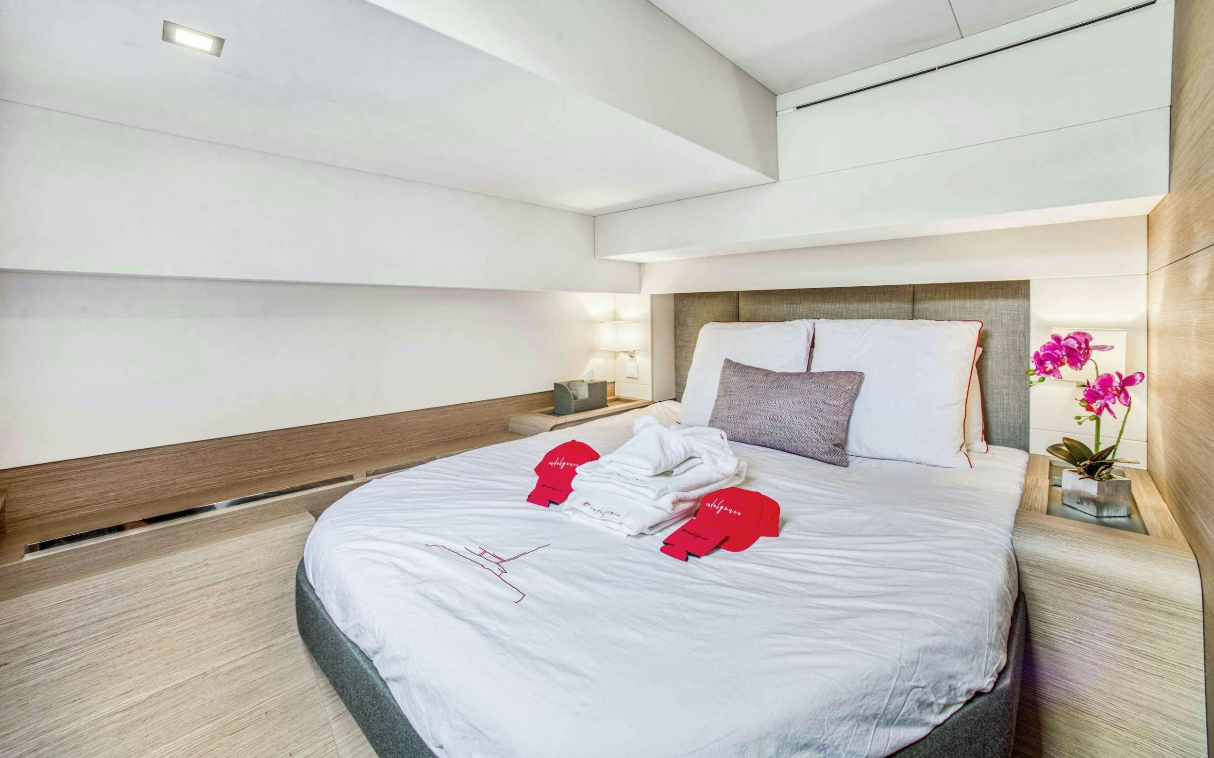 a bed with white sheets and pillows aboard INDULGENCE Yacht for Charter