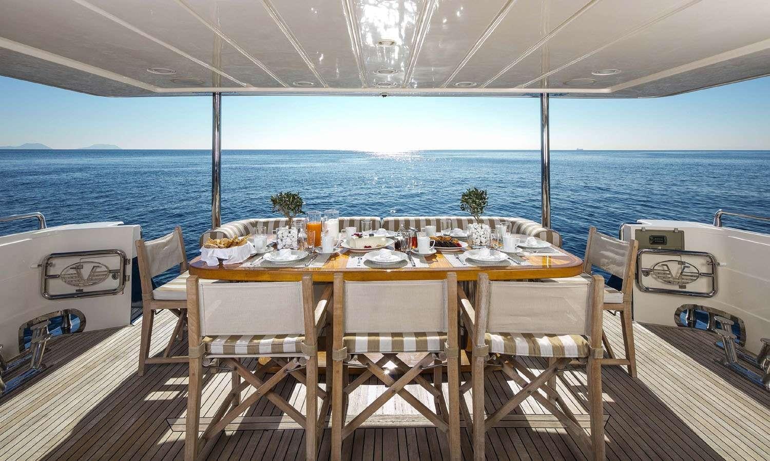 a table set for a meal on a deck overlooking the ocean aboard MYTHOS Yacht for Charter