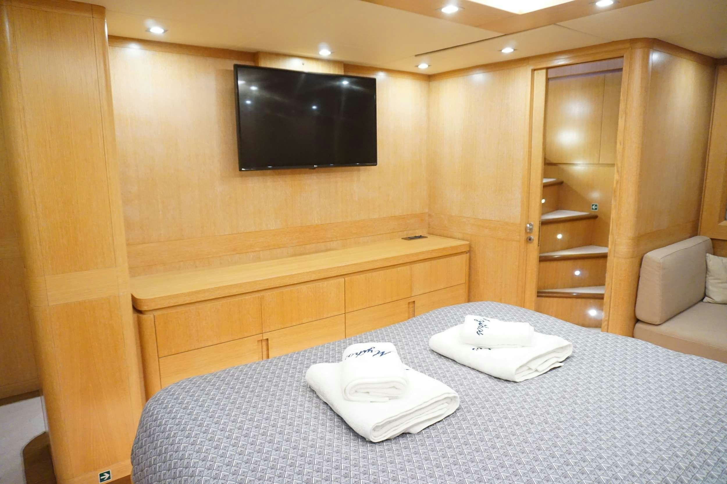 a hotel room with a tv and a table aboard MYTHOS Yacht for Charter