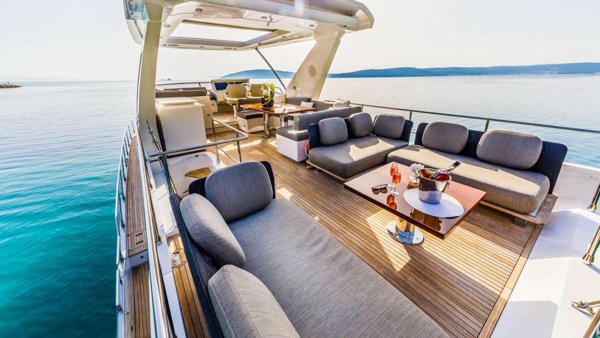 a boat with a couch and a table and chairs aboard KARAT II Yacht for Charter