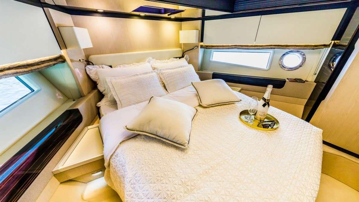 a bed with a white sheet and pillows aboard KARAT II Yacht for Charter