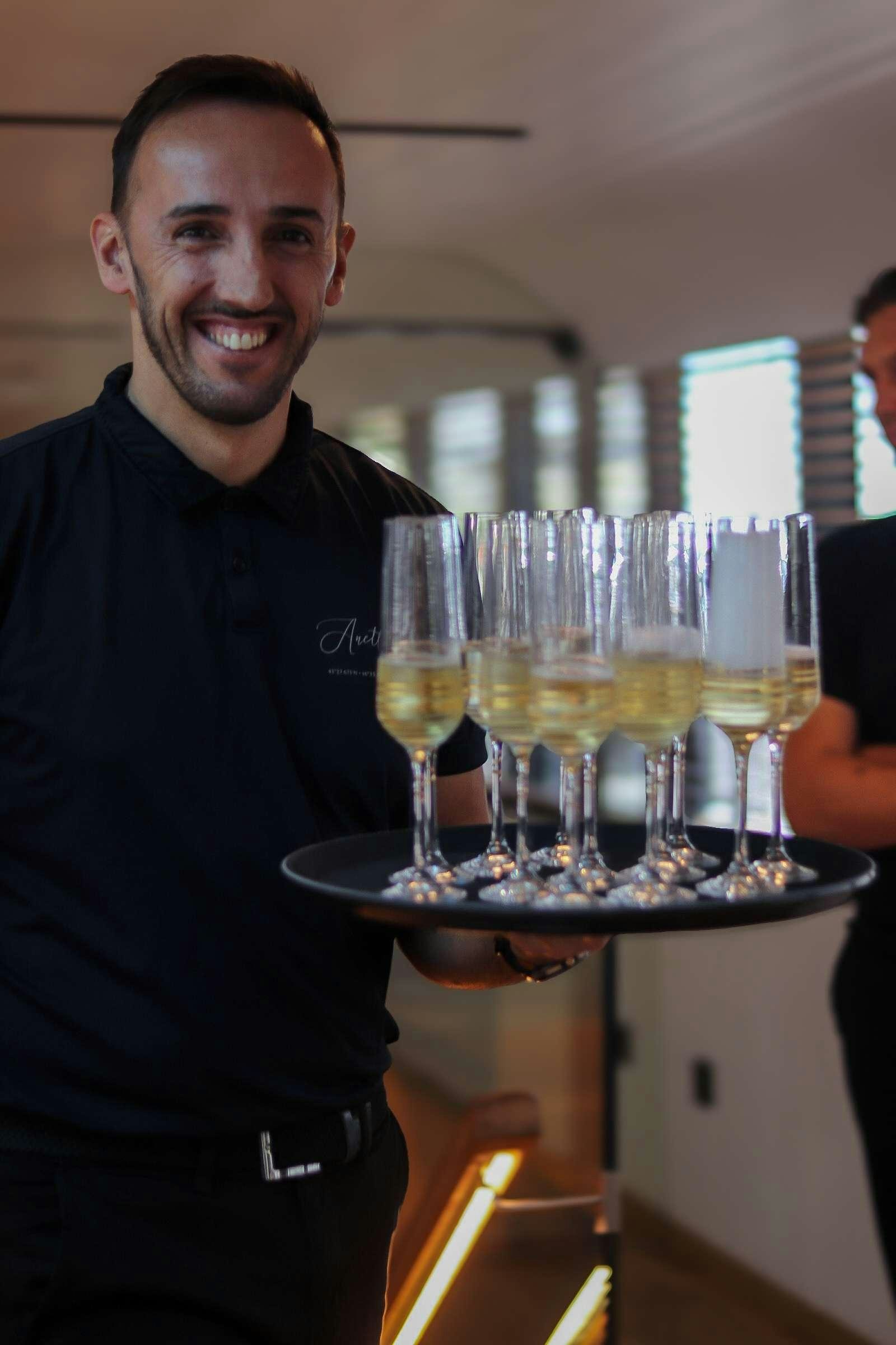a man holding a tray of wine aboard ANETTA Yacht for Charter