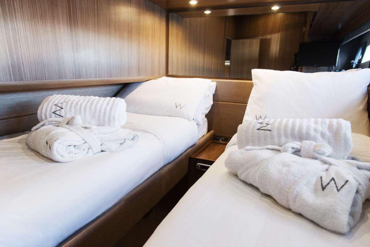 a room with beds and a wood wall aboard W Yacht for Charter