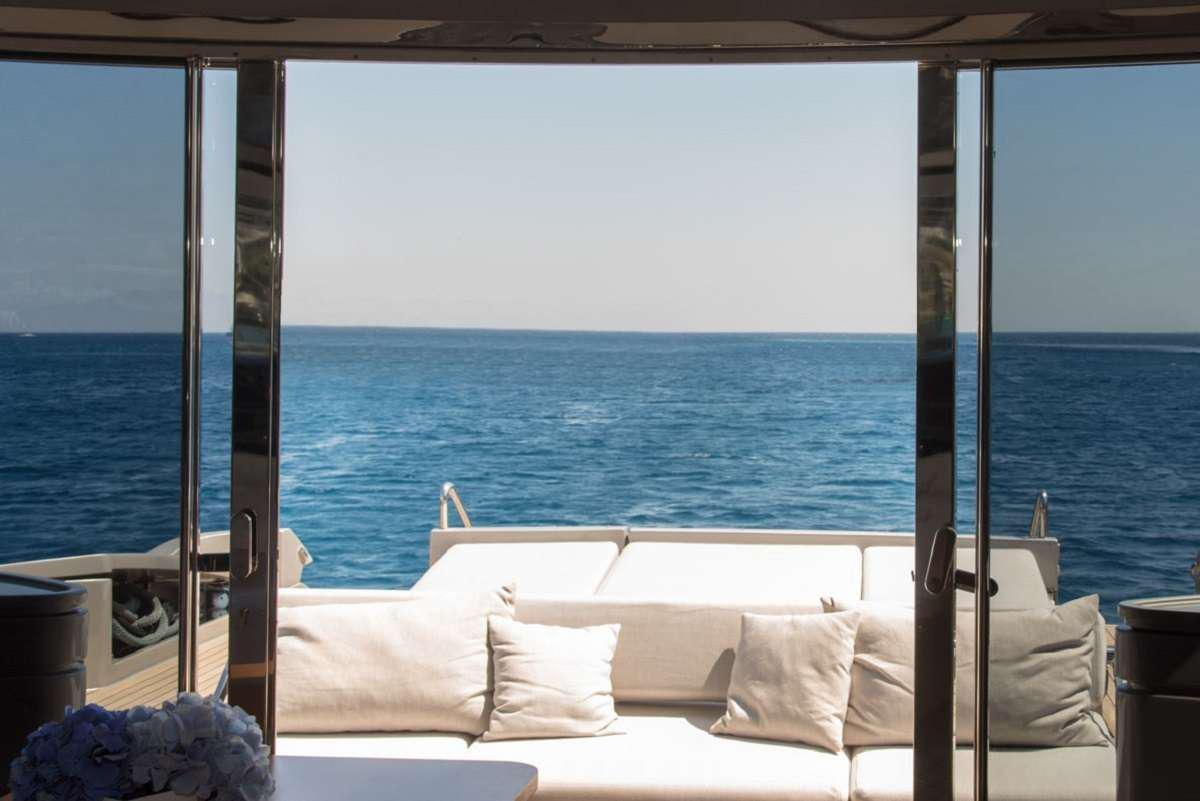 a bed and a window overlooking the ocean aboard W Yacht for Charter