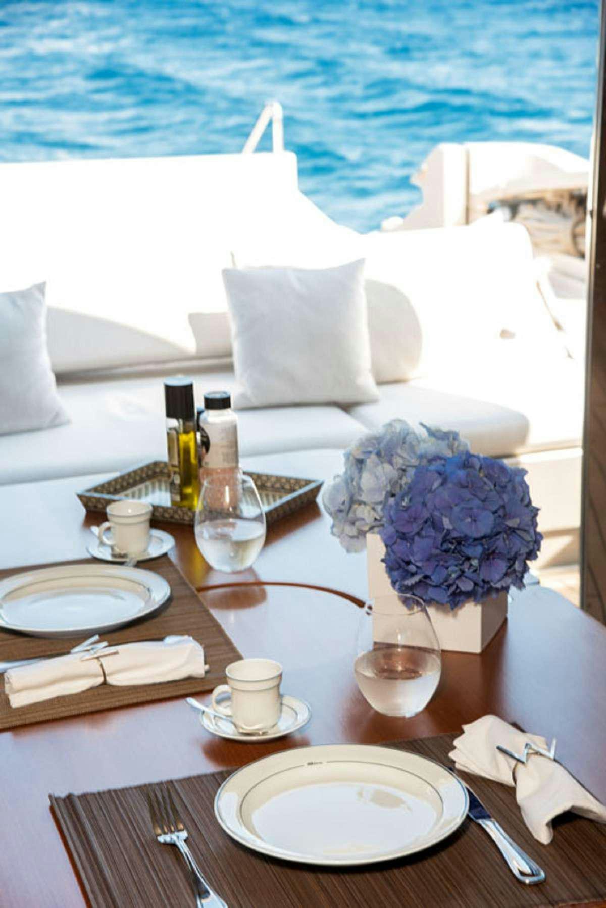 a table with plates and flowers aboard W Yacht for Charter