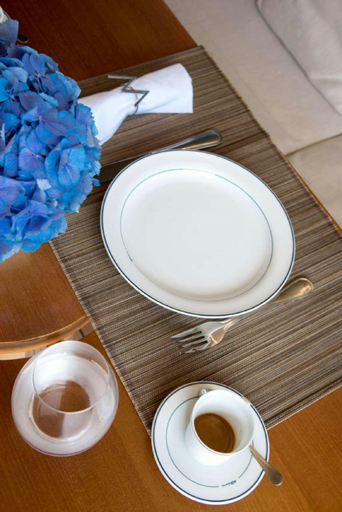 a plate with a fork and a cup of coffee on a table aboard W Yacht for Charter