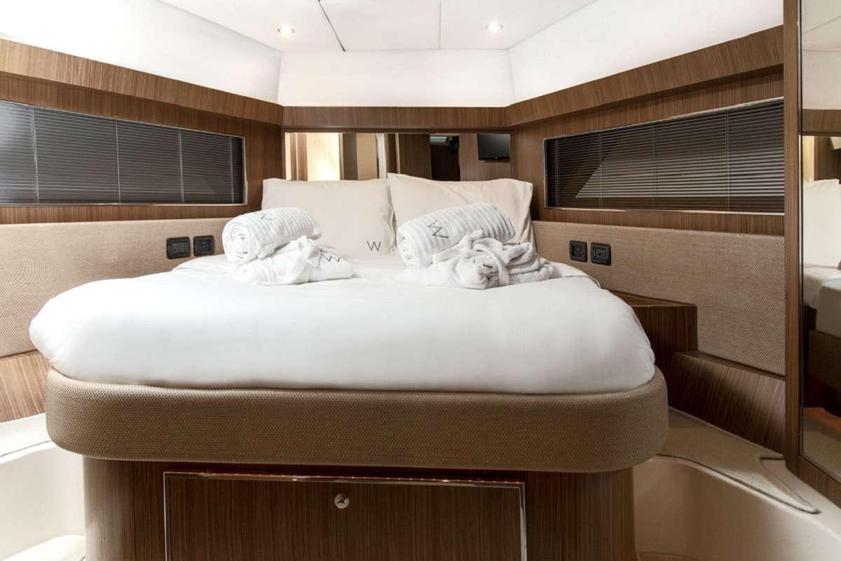 a bed with white sheets aboard W Yacht for Charter