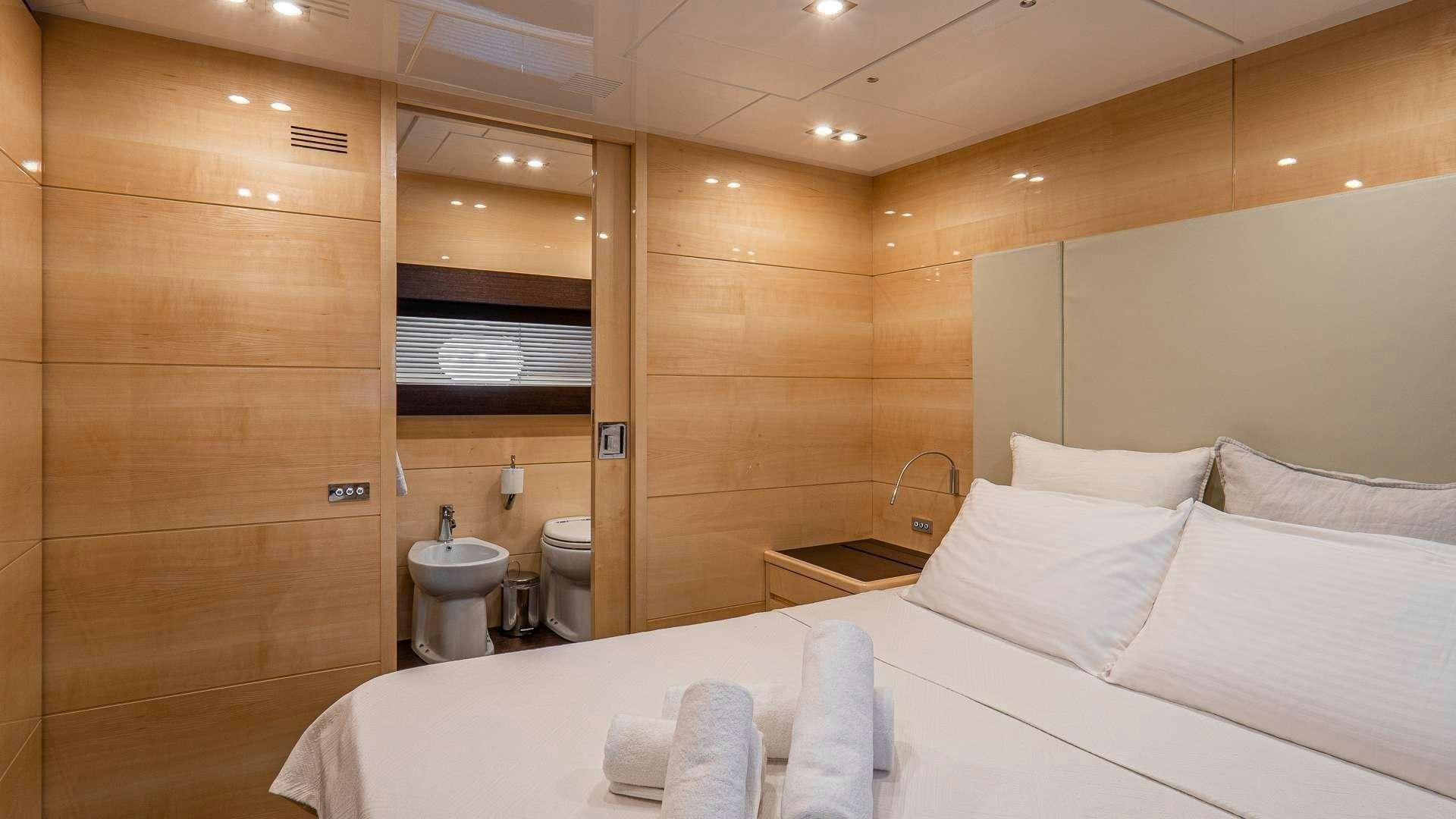 a hotel room with a bed and a toilet aboard LIBERATA Yacht for Charter