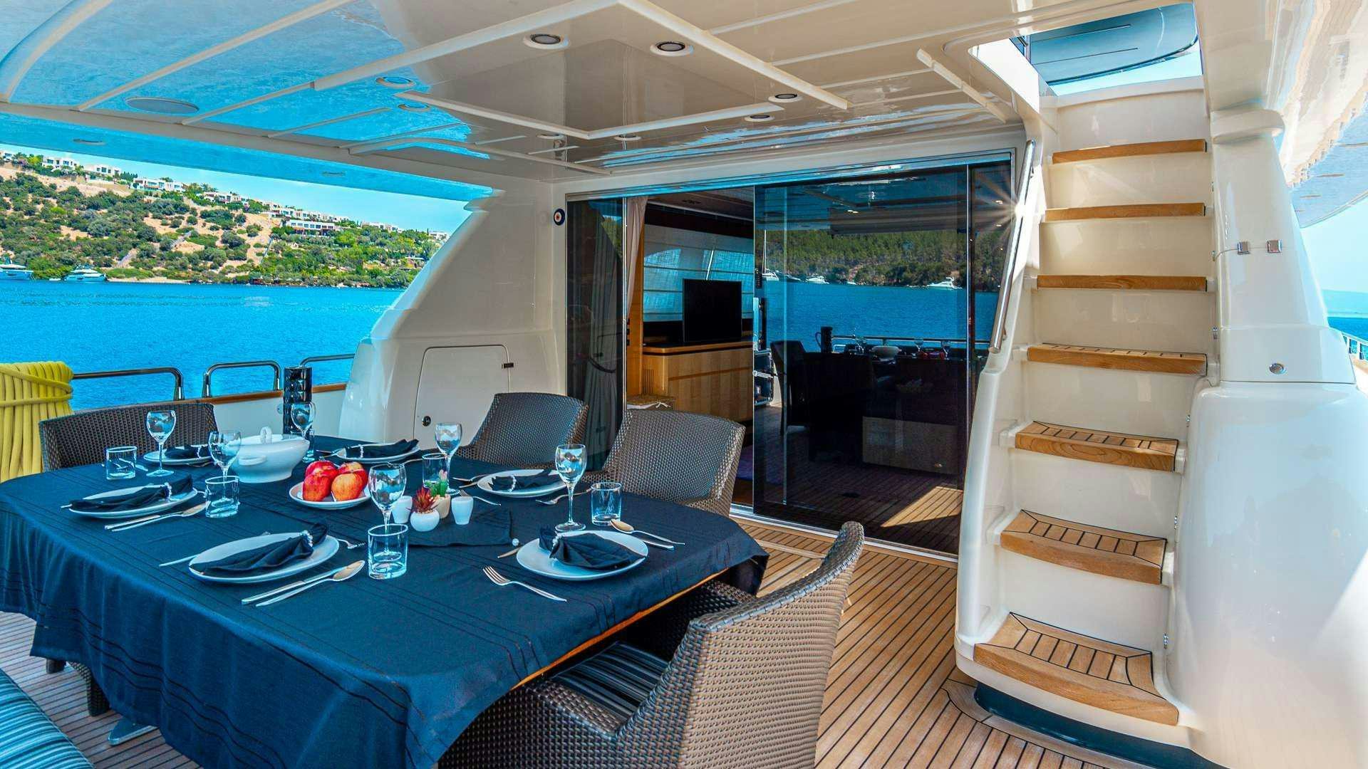 a dining table with chairs and a view of the ocean aboard LIBERATA Yacht for Charter