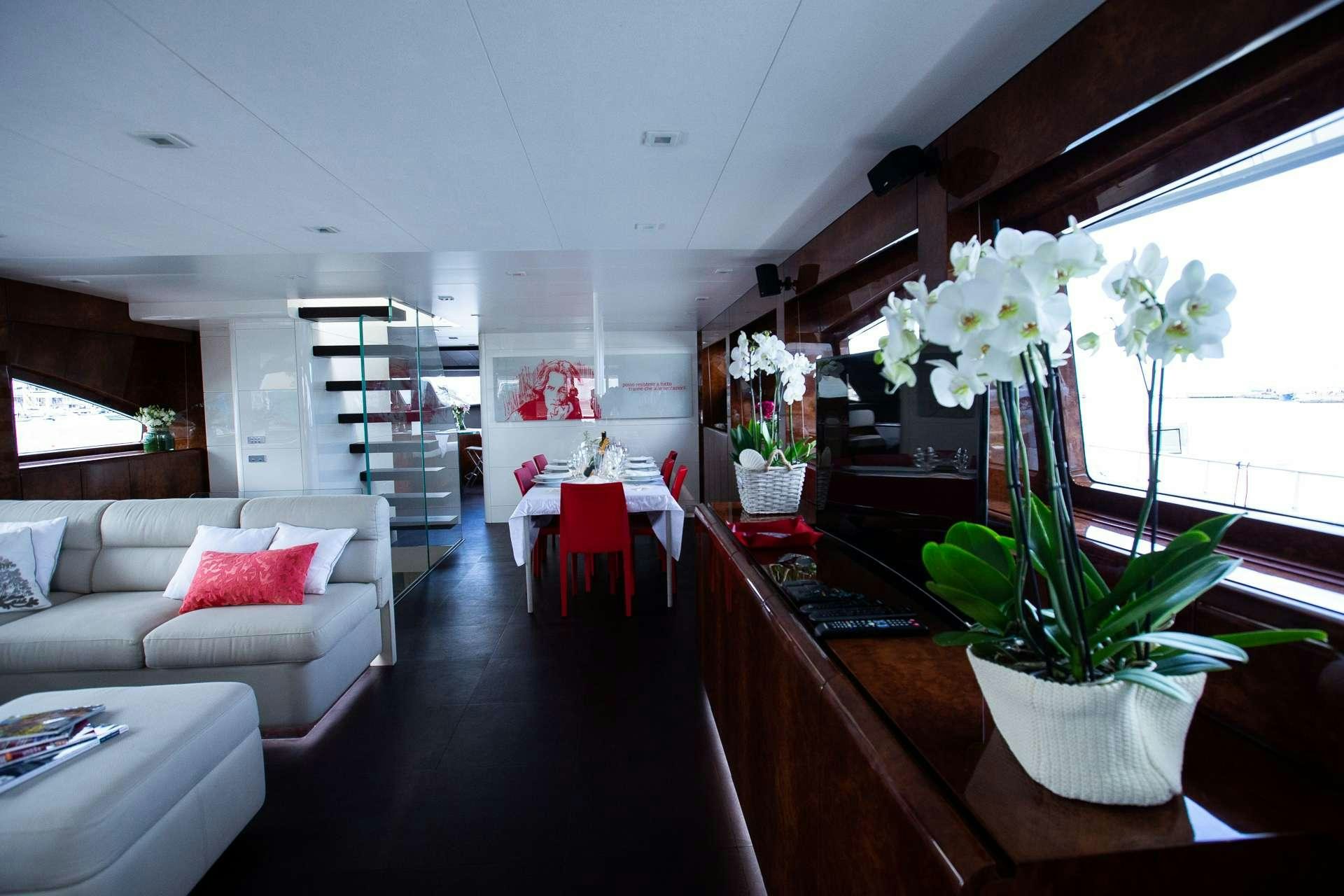 a living room with a white couch and a table with flowers aboard CAMILLA A Yacht for Charter