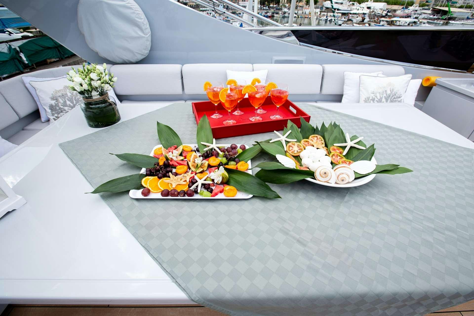 a table with flowers and plates aboard CAMILLA A Yacht for Charter