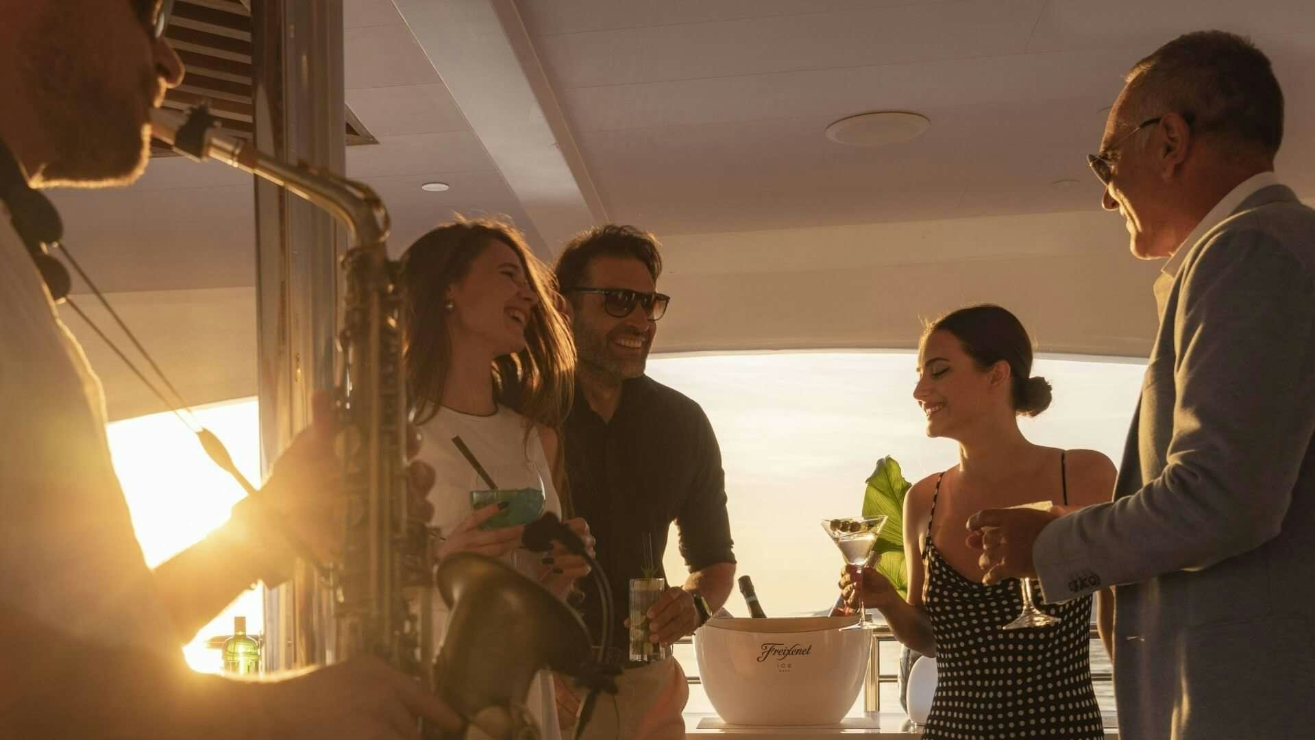 a group of people standing in a room with a table and a bowl aboard M/Y ANTHEA Yacht for Charter