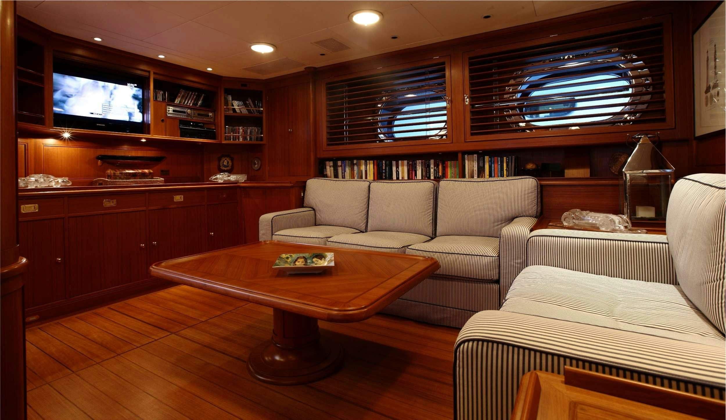 a living room with a table and couches aboard HERITAGE M Yacht for Charter